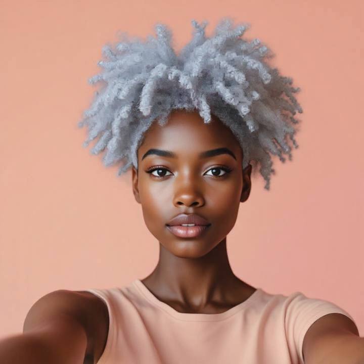 The same woman with silver gray hair keeping her coily 4C texture and deep skin tone